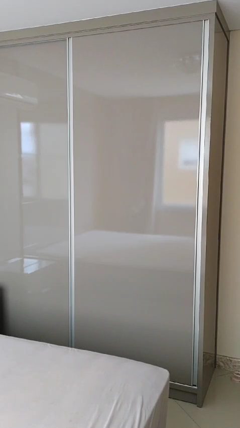Guarda-roupa planejado com portas de correr em laca, feito pela Noélio Móveis Sob Medida