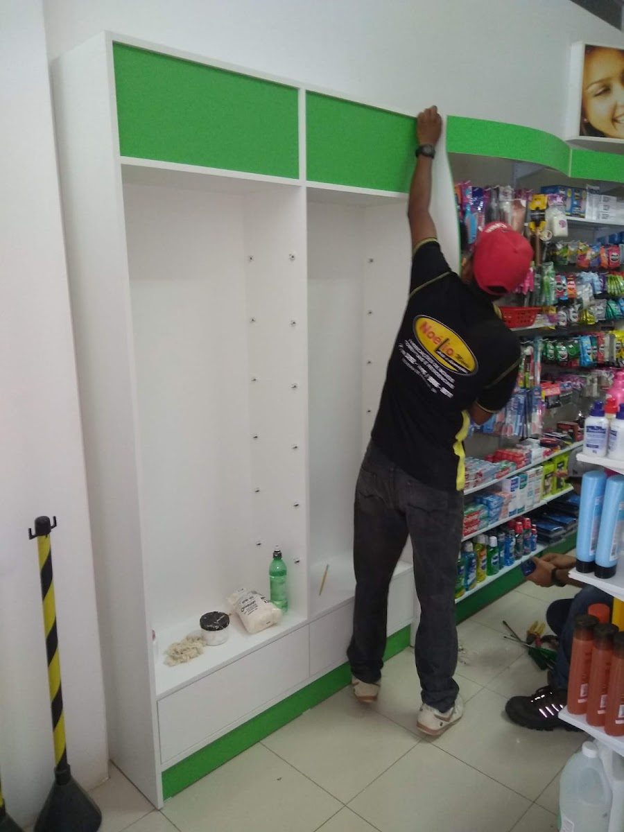Equipe da Noélio Móveis instalando um móvel planejado com uniforme da marca